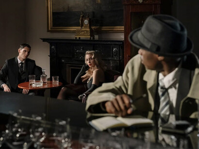 Una pareja sentada en la mesa de un bar mirando a un hombre que los observa