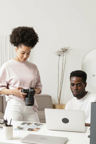 Designers collaborating over photography and digital media, symbolizing how thoughtful design strengthens institutional communication