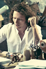 A young writer focused at home, sitting at the table and jotting down ideas in their sketchpad