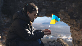 A young woman with the flag of ukraine in her hands