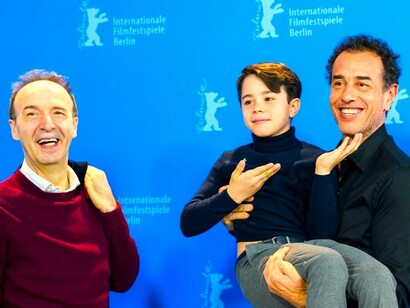 Roberto Benigni con Matteo Garrone sosteniendo en brazos al joven actor Federico Ielapi, que da vida a Pinocho en la nueva versión del director italiano