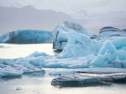 A coastal landscape covered in ice and snow, illustrating how global warming accelerates the melting of polar and marine ice