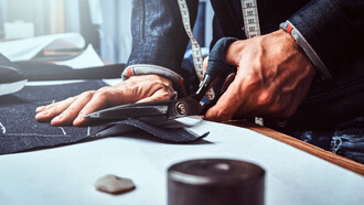 A craftsmen portraying precision and detail tailoring a Loro Piana suite