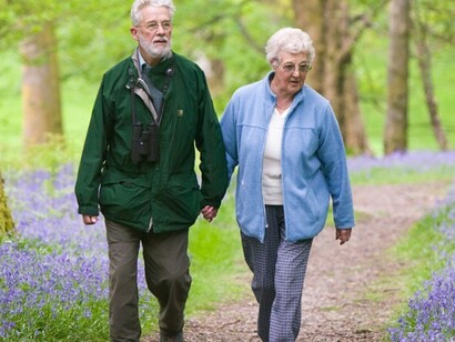 Dos personas mayores caminan por un parque