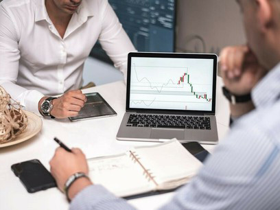 Economists analyzing data with a screen full of graphs in front of them