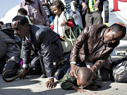 Ethiopians kiss the ground after disembarking a plane at Ben Gurion airport, outside Tel Aviv. © Oliver Weiken/EPA