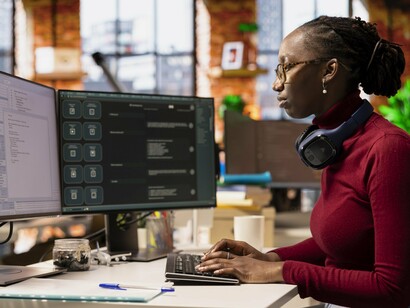 A woman writing a code, representing how access to advanced technology can allow women to take higher positions in the industry 