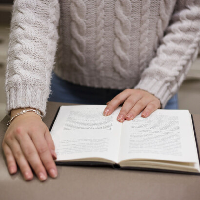 Mujer leyendo sobre una mesa. Quizá la división estricta entre filosofía y literatura nunca sea totalmente posible 