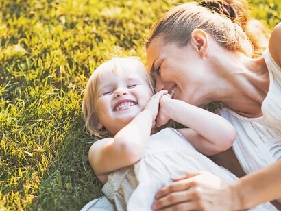 Mamma con figlia su un prato. La neotenia è una fase di sviluppo del piccolo rallentata in cui il cervello del neonato impiega più tempo per raggiungere il suo massimo sviluppo