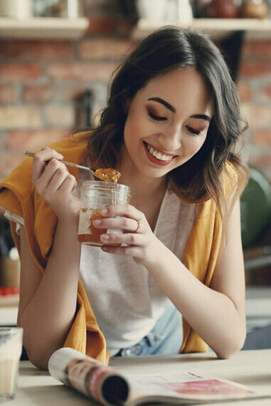 Embracing a post-holiday diet, a young woman eats a vibrant salad, packed with fruits and vegetables for a healthy boost