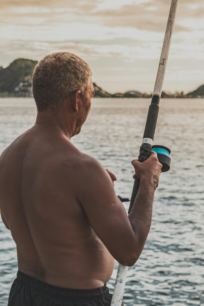 Pescador prepara o anzol com calma e assertividade no momento de estratégia e atenção plena de seu trabalho