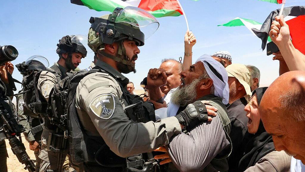 Soldado israelí discute con un palestino en una manifestación cerca de Gaza