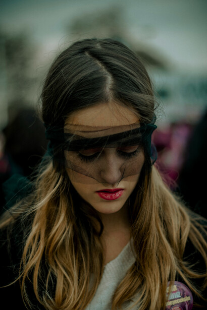 A woman in a transparent blindfold screaming in the middle of the street