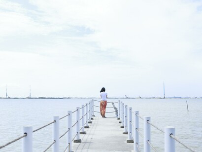 Woman standing alone by the ocean