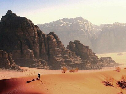 A man hiking a dune in Wadi Rum, Jordan