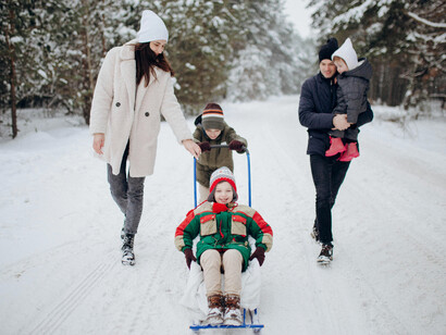 Family having fun together in the snow during winter