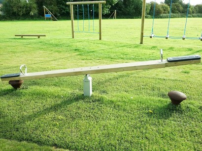 A swing set is vacated and waiting for someone to use them to go up and down