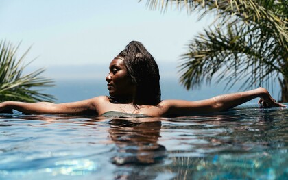 Woman in an infinity pool overlooking Cabo San Lucas, Baja California Sur, Mexico