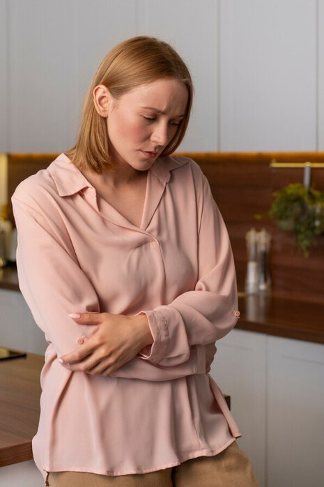 A woman with a stomach ache, emphasizing the connection between gut health and the gut-brain axis, and the therapeutic effect of probiotics