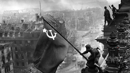 The legacy of WWII: Soviet soldiers raise the USSR flag over the Reichstag in Berlin at the end of the Second World War in 1945. The photograph is attributed to Soviet war photographer Viktor Temin