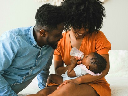 Parents carrying a baby, showing affection