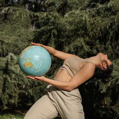 The Earth globe rests in the woman's hand, a powerful reminder of her role as a global citizen