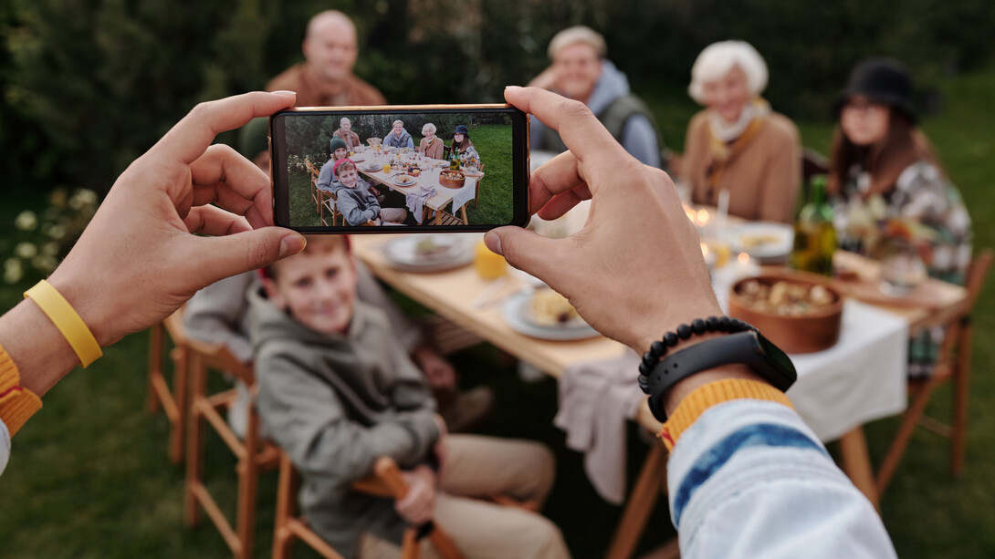 A smartphone captures a family having dinner