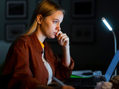 A woman working at her laptop, immersed in the writing process, reflecting her creative and personal writing journey