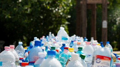 Assorted plastic bottles, e-waste recycling, and renewable resources contribute to the creation of recycled fashion products, showcasing the potential of sustainable materials in the fashion industry