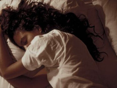 A depressed woman laying on the bed