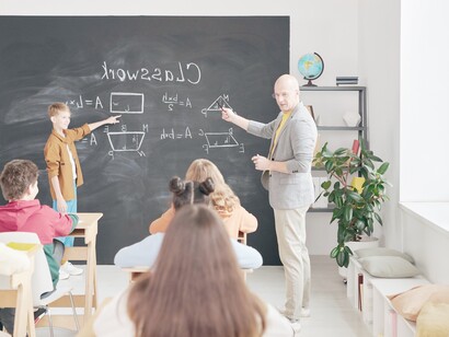 Teacher and students in a classroom. The practice of teaching is a careful ritual