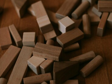 Scattered building blocks strewn across the ground, representing the dismantling of an old world order awaiting reconstruction
