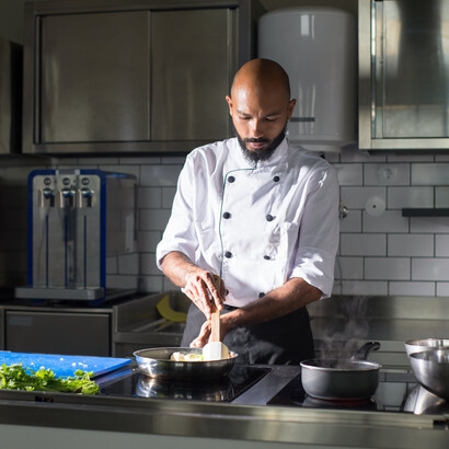 Chefe de cozinha usa técnica de redução para cozinhar alimento em frigideira