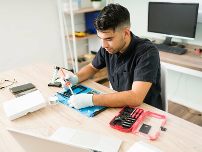 A technician repairing a mobile phone. Nowadays, when something breaks, the most common reaction is to replace it rather than repair it