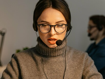 A customer service representative speaking through a headset, symbolizing the legitimate support channels attackers attempt to imitate