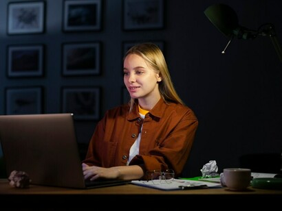 Writing with intention, a woman at her laptop embraces her creative process and personal journey of self-expression
