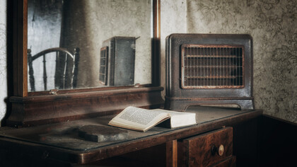Polvoriento escritorio con un libro abandonado de una vieja habitación