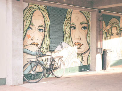 Bicicleta apoyada en un mural de la calle de Arte Radical en Berlín, Alemania