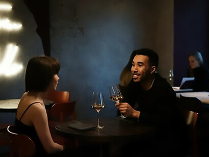 A woman and a man enjoying a glass of wine together on a date