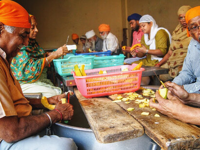 A team of volunteers, diligently chop a variety of colorful vegetables