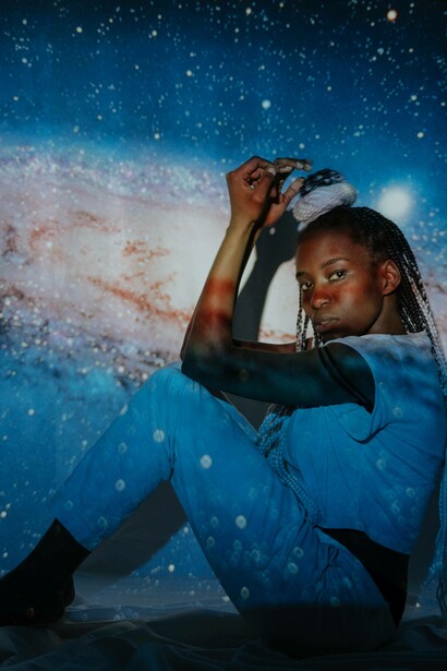 Woman lays by an image of the galaxy