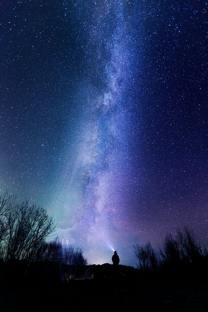 Un hombre iluminando el cielo nocturno
