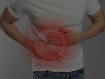 A man places two hands on his abdomen as a result of pain caused by his liver