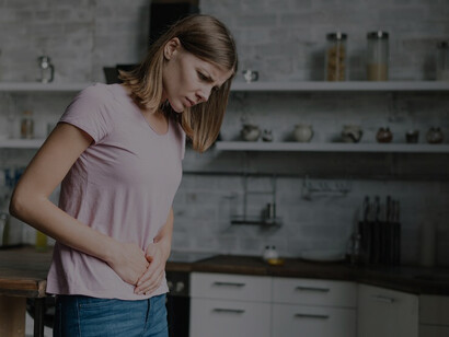 A young woman experiencing stomach pain, illustrating common food intolerance symptoms and effective management strategies like the elimination diet