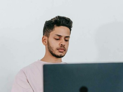 A man is scanning all the paid search ads from his laptop