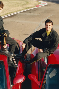 Os pilotos Carlos Sainz e Charles Leclerc vestem terno técnico de lã com fita de gorgorão, suéter de manga longa e botas de couro; Irina Shayk, com terno napa emborrachado, luvas e óculos de couro para a FERRARI, fotografado por Theo Liu. Descubra como a Fórmula 1 se tornou um fenômeno de popularidade e negócios além das corridas, atraindo marcas de luxo e celebridades