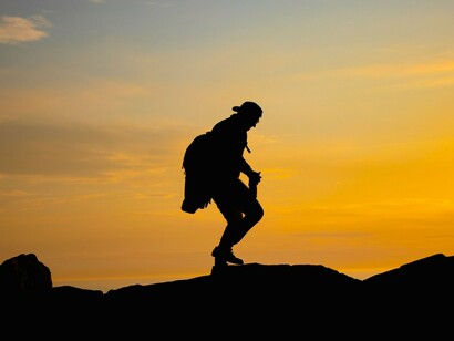 A traveller going on despite the steep path ahead, symbolising perseverance over fear and doubt