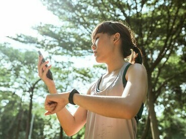 Une personne surveillant ses indicateurs de forme physique lors d’un entraînement en plein air, reflétant le rôle croissant des technologies portables dans la vie quotidienne.