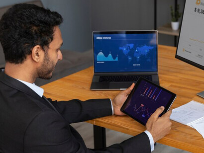 A business professional reviewing financial graphs and data visualizations to optimize digital marketing strategies