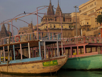 A couple of boats gently float in the tranquil waters of Varanasi, Uttar Pradesh, India, creating a picturesque scene